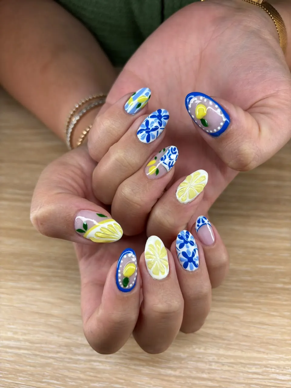 Blue and white floral nail art with painted lemon detail